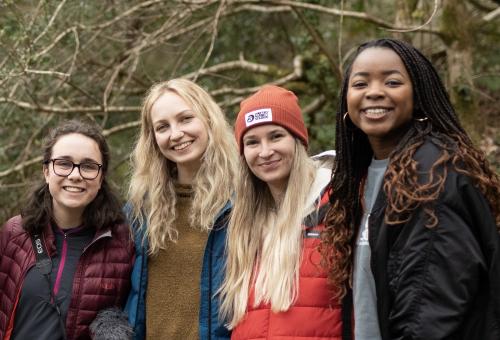 Four young women from Earth Minutes smiling at camera